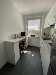 a white kitchen with a desk and a window at Apartament Słowackiego 29 in Gdańsk