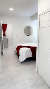 a white room with a bed and a mirror at Cozy Studio…5 min away from LAS Airport. “ in Las Vegas