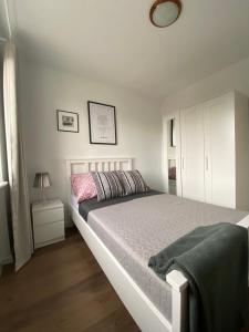 1 dormitorio con 1 cama blanca y armario blanco en Apartament Słowackiego 29 en Gdansk