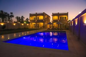 a villa with a swimming pool in front of a house at Royal Nile Villas - Pool View Apartment 1 in Luxor