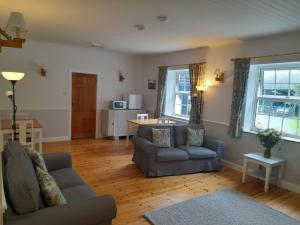 a living room with two couches and a table at North Headborough in Haverfordwest
