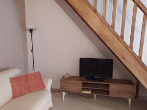 a living room with a couch and a television on a wooden table at Home sweet home in Melilli