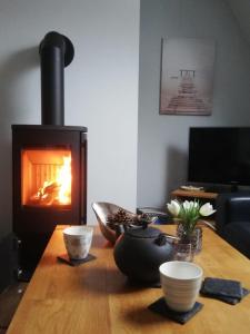 ein Wohnzimmer mit einem Holztisch und einem Kamin in der Unterkunft Ferienhaus-Slanitz in Harlesiel