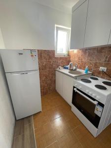 a kitchen with a white refrigerator and a stove at Rock Hostel in Pristina