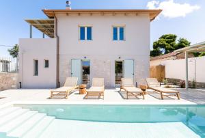 a villa with a swimming pool in front of a house at Casa Oliva in Tsoukalades