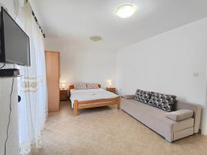 a living room with a couch and a flat screen tv at MM Apartments in Budva