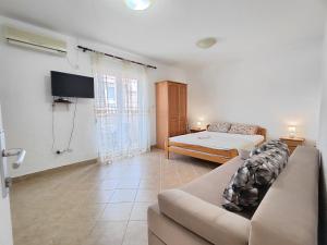 a living room with a couch and a bed at MM Apartments in Budva