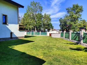 un patio con valla y césped verde en Pensjonat Lubar, en Dziwnów