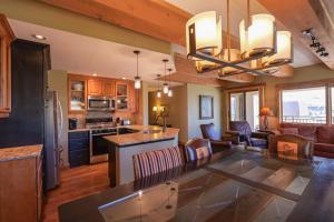 a kitchen and living room with a large dining table at 5th Floor 2BD 2BA Condo with Magnificent Views in Crested Butte
