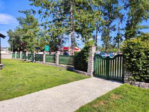 a fence in a yard with grass and a sidewalk at Pensjonat Lubar in Dziwnów