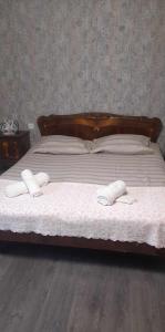 a bed with two white towels on top of it at House of greenery in Kutaisi