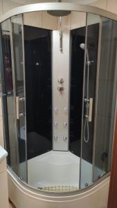 una doccia con porte in vetro in bagno di Apartament GUNER a Bełchatów