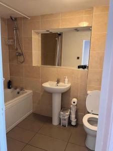 La salle de bains est pourvue d'un lavabo, de toilettes et d'une baignoire. dans l'établissement Spacious and comfy, à Woolwich