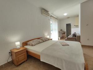 a bedroom with a large bed and a living room at MM Apartments in Budva