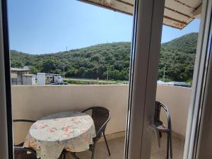 a table and chairs on a balcony with a view of a mountain at MM Apartments in Budva