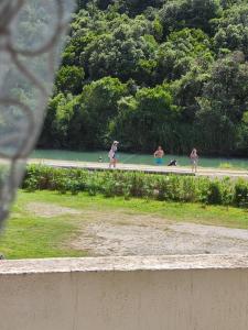 a group of people walking on a road next to a lake at MM Apartments in Budva