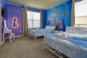 a bedroom with two beds and a wall with a mural at Thematic Home with Pool Spa and Game room! in Kissimmee