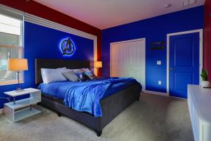 a blue bedroom with a bed and a blue wall at Thematic Home with Pool Spa and Game room! in Kissimmee