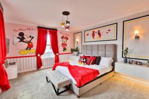 a bedroom with a large bed with red curtains at Thematic Home with Pool Spa and Game room! in Kissimmee