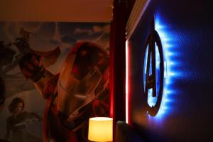 a lit candle next to a wall with a superhero picture at Thematic Home with Pool Spa and Game room! in Kissimmee