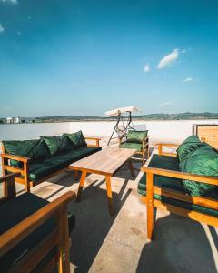 a deck with couches and tables on the water at Don_house in Pristina