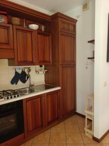 a kitchen with wooden cabinets and a sink at L'angolo di Anna in Pieve di Soligo