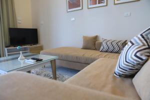 - un salon avec deux canapés et une télévision dans l'établissement Royal Nile Villas - Pool View Apartment 2, à Louxor