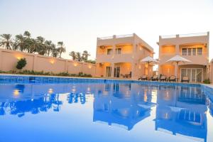 a large swimming pool in front of a house at Royal Nile Villas - Pool View Apartment 2 in Luxor