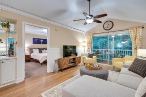 a living room with a couch and a tv at High-End Pawleys Island Condo with Porch and Pools! in Pawleys Island
