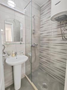 a bathroom with a sink and a glass shower at MM Apartments in Budva