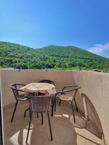 a table and chairs on a balcony with a view of a mountain at MM Apartments in Budva