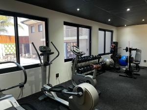 a gym with two treadmills and two machines at Riverleaf Hotel in Brits