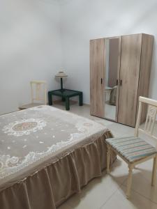 1 dormitorio con cama, silla y espejo en Home sweet home, en Melilli