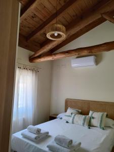 1 dormitorio con 1 cama con toallas en La casita de Ra, en Castillo de Bayuela