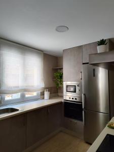 a kitchen with a stainless steel refrigerator and microwave at La casita de Ra in Castillo de Bayuela