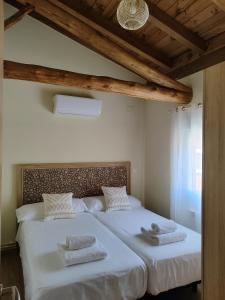 1 dormitorio con 1 cama grande y toallas. en La casita de Ra, en Castillo de Bayuela