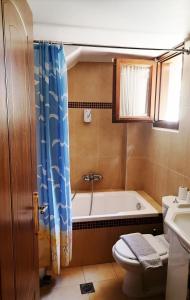 a bathroom with a tub and a toilet and a sink at Dallia Loft Space in Goumenissa