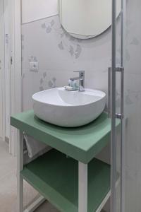 a white sink on a green table in a bathroom at Al Chiaro di Luna Luxury Suites AMALFI COAST in Vietri