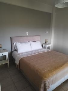een slaapkamer met een groot bed met witte kussens bij Mary's Panorama Houses in Gialova