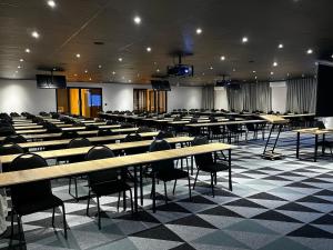 an empty lecture hall with tables and chairs at Riverleaf Hotel in Brits