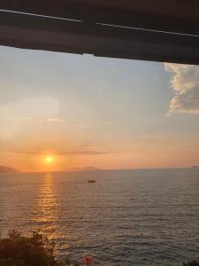 - un coucher de soleil sur l'océan avec un bateau dans l'eau dans l'établissement Darla Sea View Apartment, à Vlorë