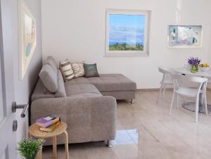 sala de estar con sofá y mesa en Modern Apartment for 4 persons, Sea view, near the beach, Parking, en Supetar