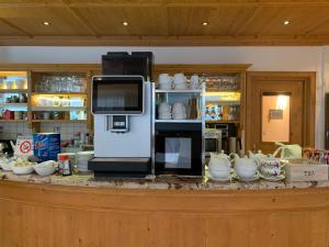 a cash register on a counter with bowls and cups at B&B MARINA contacless check in in Santa Cristina in Val Gardena