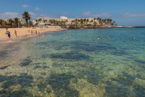 a group of people in the water at a beach at Tyler's House Ocean View in Costa Teguise