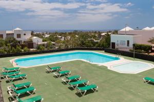 a swimming pool with chaise lounge chairs and a pool at Tyler's House Ocean View in Costa Teguise