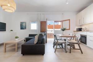 a living room with a couch and a table and a kitchen at Balcon de Porteria in Telde