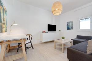 uma sala de estar branca com um sofá e uma mesa em Balcon de Porteria em Telde
