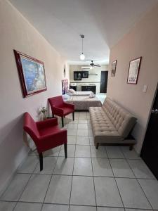 a living room with a couch and red chairs at Habitaciones Amuebladas Castillo98 in Veracruz