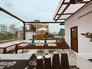 a rooftop patio with tables and chairs and a view of the city at Rango Hostel Boutique in Medellín