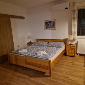 een bed in een slaapkamer met 2 nachtkastjes en 2 lampen bij Apartmán 33 in Teplice nad Metují